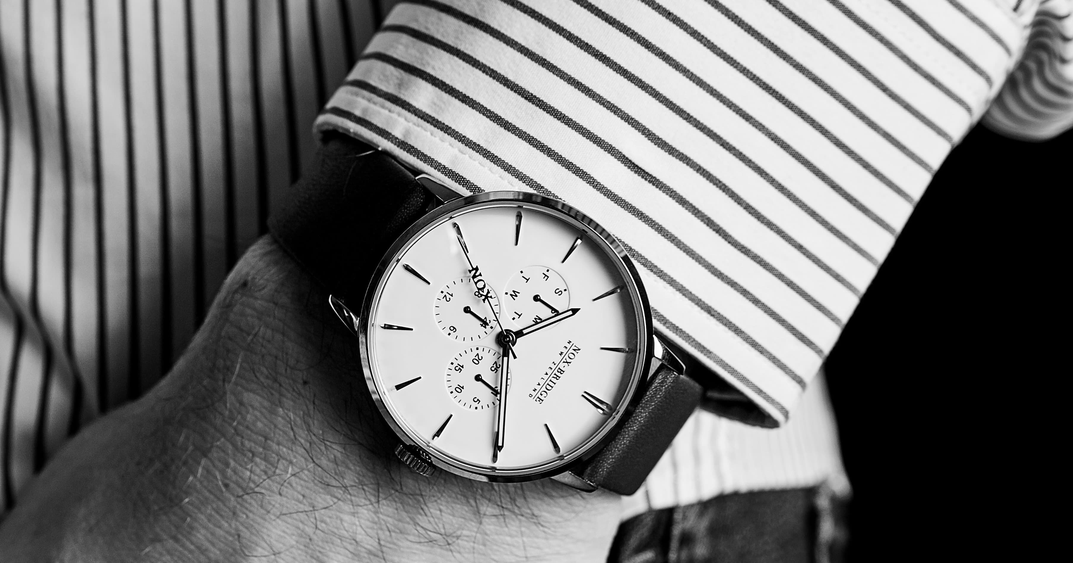 Noxbridge watch face detail with striped shirt cuff